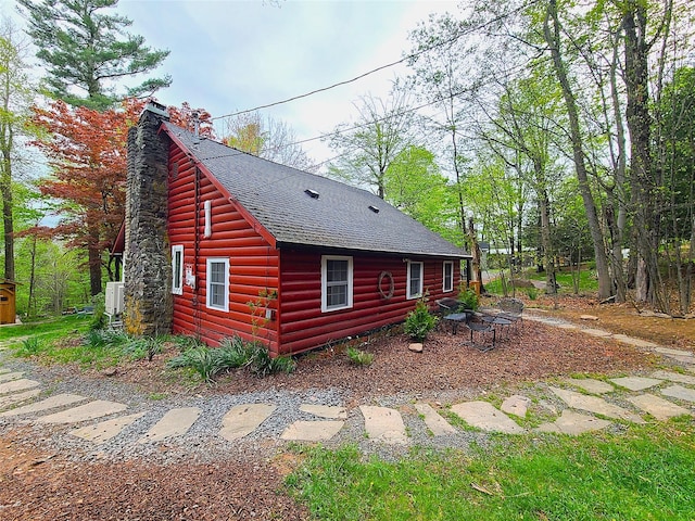 112 E Thompson Pl, Smallwood, NY 12778 - view of home's exterior with a shingled roof, a chimney, and faux log siding
