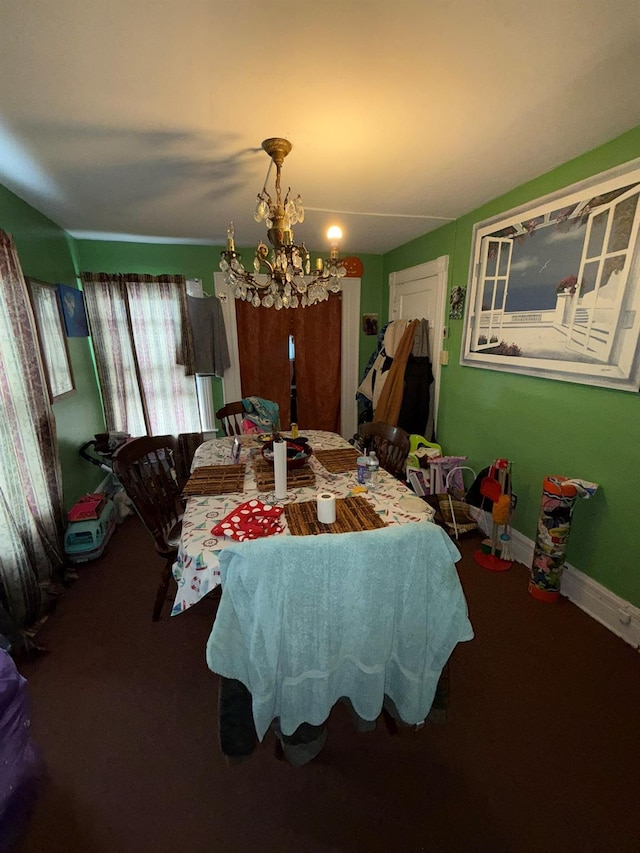 carpeted dining space featuring a chandelier and baseboards