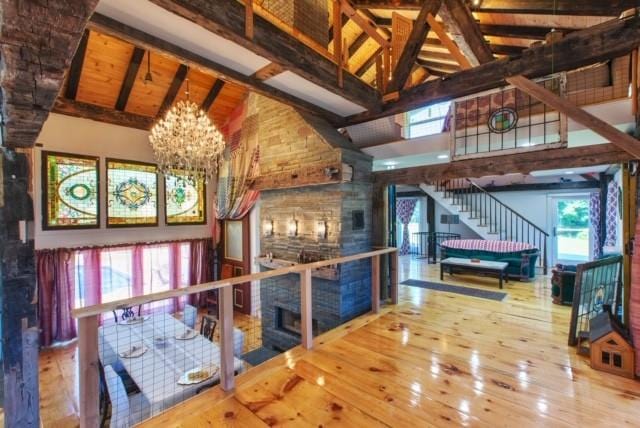 5 Downer Ln, Woodstock, NY 12498 - interior space with wood-type flooring, high vaulted ceiling, beam ceiling, a fireplace, and a notable chandelier