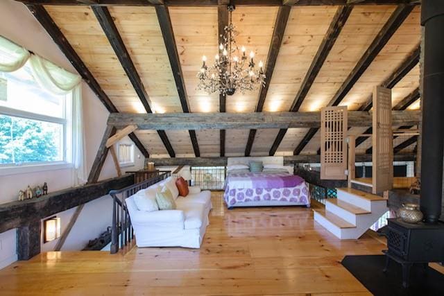 5 Downer Ln, Woodstock, NY 12498 - bedroom featuring hardwood / wood-style floors, a wood stove, wooden ceiling, a notable chandelier, and vaulted ceiling with beams