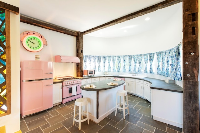 5 Downer Ln, Woodstock, NY 12498 - kitchen with freestanding refrigerator, under cabinet range hood, range with two ovens, dark countertops, and white cabinets