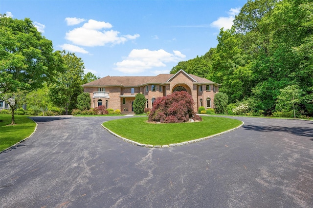 9 Oak Ridge Ct, West Harrison, NY 10604 - colonial-style house with curved driveway, brick siding, and a front yard