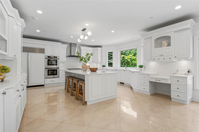 9 Oak Ridge Ct, West Harrison, NY 10604 - kitchen with paneled built in fridge, wall chimney exhaust hood, light countertops, white cabinets, and recessed lighting
