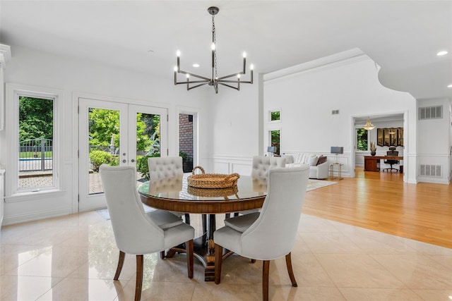 9 Oak Ridge Ct, West Harrison, NY 10604 - dining space with healthy amount of natural light, a chandelier, light tile patterned floors, a decorative wall, and crown molding