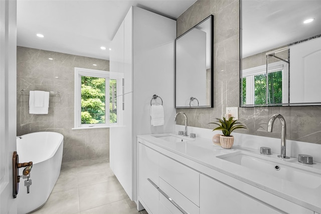 9 Oak Ridge Ct, West Harrison, NY 10604 - full bathroom featuring tile walls, a soaking tub, double vanity, tile patterned flooring, and recessed lighting