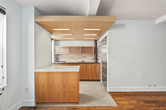 kitchen with light wood finished floors, tasteful backsplash, baseboards, and open shelves