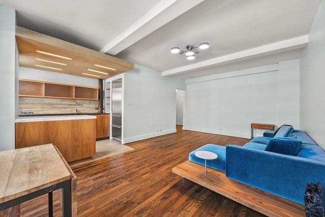 living area with beamed ceiling, baseboards, and wood finished floors