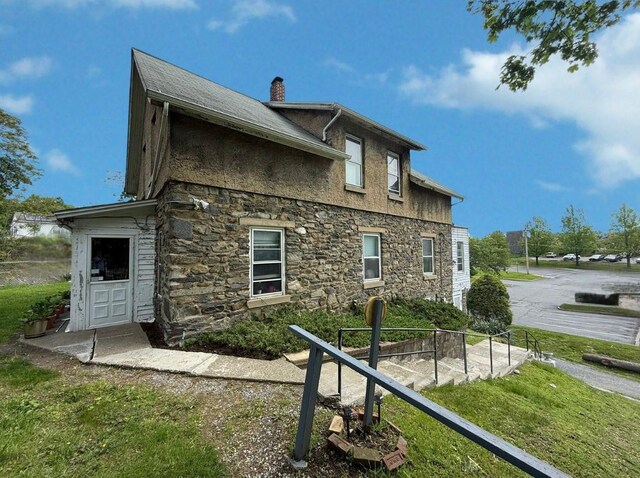 17 Springside Ave, Poughkeepsie, NY 12603 - back of property with stone siding, a chimney, and a lawn