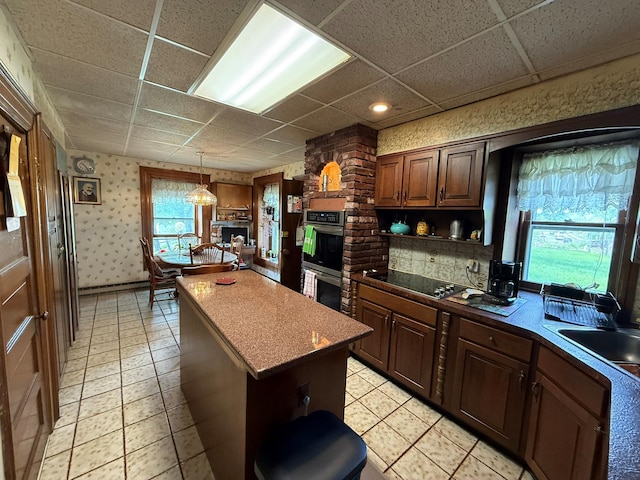 17 Springside Ave, Poughkeepsie, NY 12603 - kitchen with double oven, a paneled ceiling, a fireplace, black electric cooktop, and a kitchen island