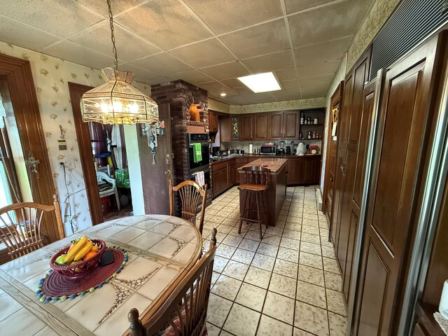 17 Springside Ave, Poughkeepsie, NY 12603 - dining room featuring wallpapered walls, a chandelier, a paneled ceiling, and light tile patterned flooring