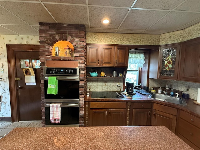 17 Springside Ave, Poughkeepsie, NY 12603 - kitchen with wallpapered walls, stainless steel double oven, a sink, a paneled ceiling, and black electric stovetop