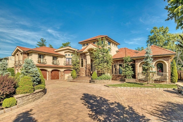 959 S End Rd, Woodmere, NY 11598 - mediterranean / spanish home featuring stone siding, decorative driveway, a tiled roof, and stucco siding