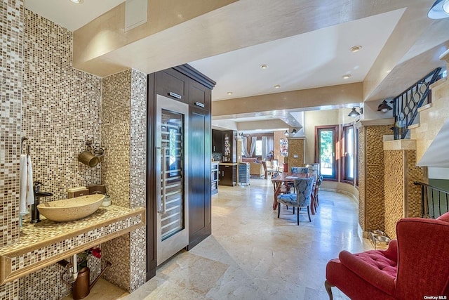 959 S End Rd, Woodmere, NY 11598 - kitchen featuring a sink, tasteful backsplash, open floor plan, dark brown cabinetry, and beverage cooler