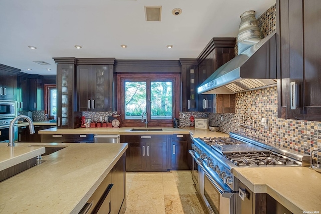 959 S End Rd, Woodmere, NY 11598 - kitchen featuring appliances with stainless steel finishes, a sink, light countertops, tasteful backsplash, and wall chimney range hood