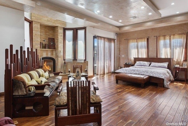959 S End Rd, Woodmere, NY 11598 - bedroom with wood finished floors, a tray ceiling, a stone fireplace, and recessed lighting
