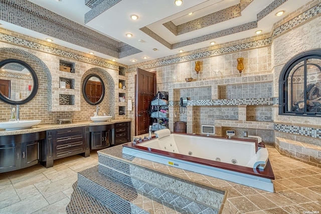 959 S End Rd, Woodmere, NY 11598 - bathroom featuring a tray ceiling, a tub with jets, recessed lighting, double vanity, and tile walls