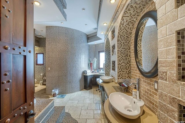 959 S End Rd, Woodmere, NY 11598 - bathroom with stone tile flooring, walk in shower, tile walls, and a sink