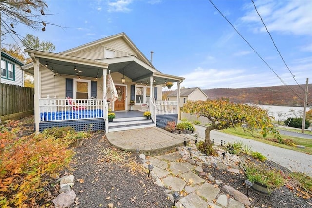 bungalow with a porch and fence