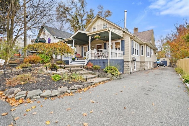 bungalow with covered porch and a chimney