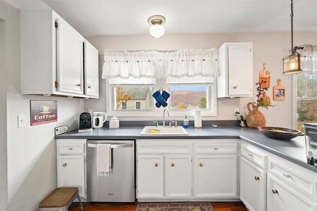 kitchen featuring a sink, white cabinetry, stainless steel dishwasher, hanging light fixtures, and dark countertops