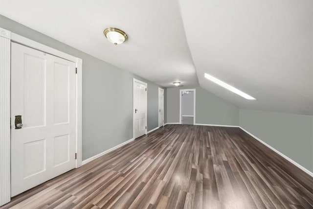 bonus room with vaulted ceiling, wood finished floors, and baseboards