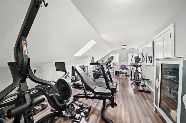 workout room with vaulted ceiling and wood finished floors