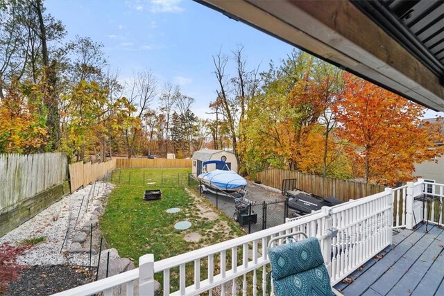 exterior space featuring an outbuilding, a lawn, a fenced backyard, and a storage unit