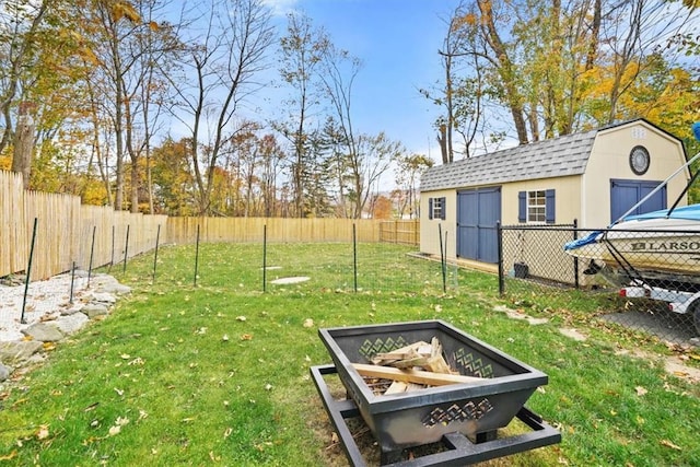 view of yard with an outbuilding, a fenced backyard, and a storage unit
