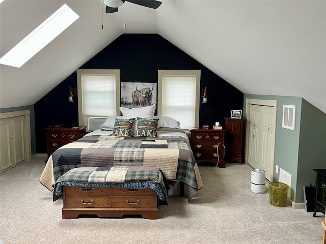 carpeted bedroom with cooling unit, vaulted ceiling with skylight, a ceiling fan, and visible vents