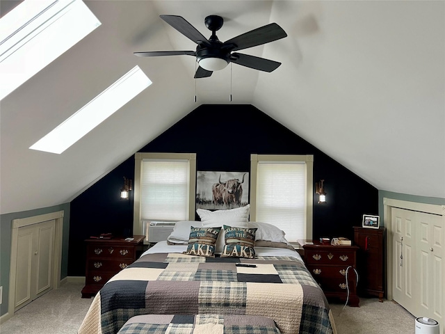 bedroom with light carpet, a ceiling fan, and vaulted ceiling with skylight