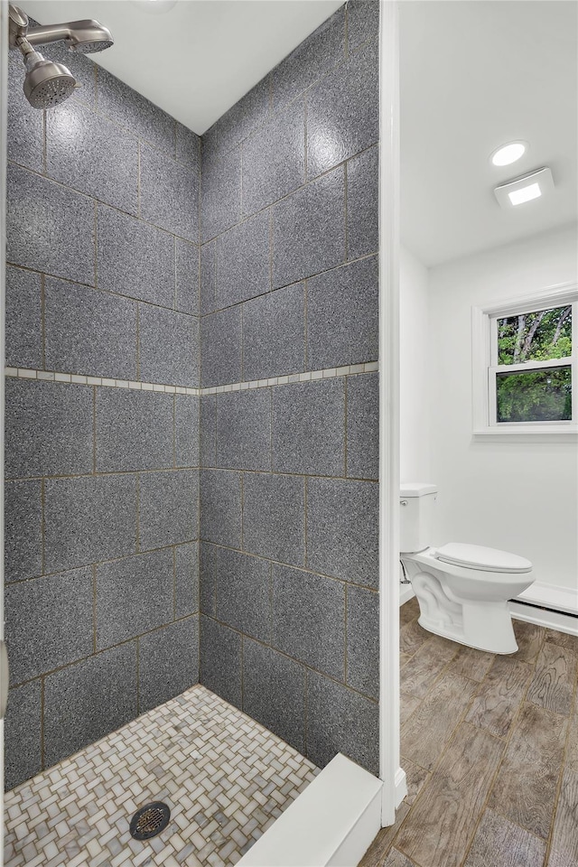 3 Russet Ln, Lake Grove, NY 11755 - bathroom with toilet, a baseboard heating unit, a shower stall, and wood finished floors