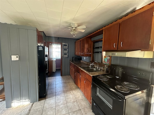 kitchen with black appliances, under cabinet range hood, a sink, a ceiling fan, and light tile patterned floors