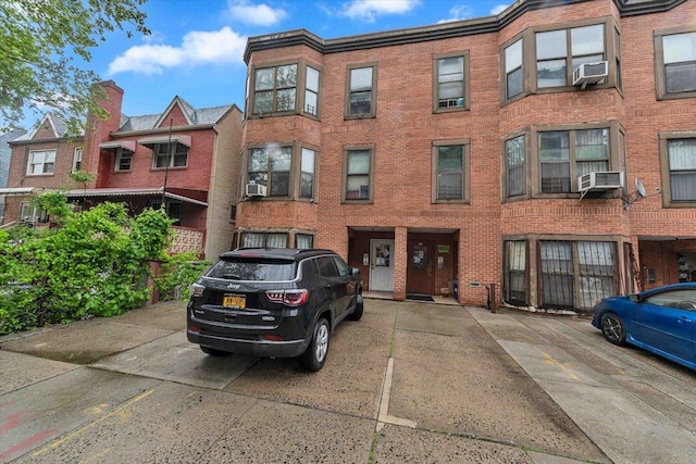 view of property featuring cooling unit and uncovered parking