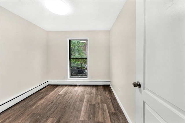unfurnished room featuring baseboards, a baseboard radiator, and wood finished floors