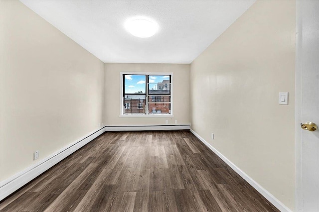 empty room featuring dark wood finished floors, baseboards, and baseboard heating