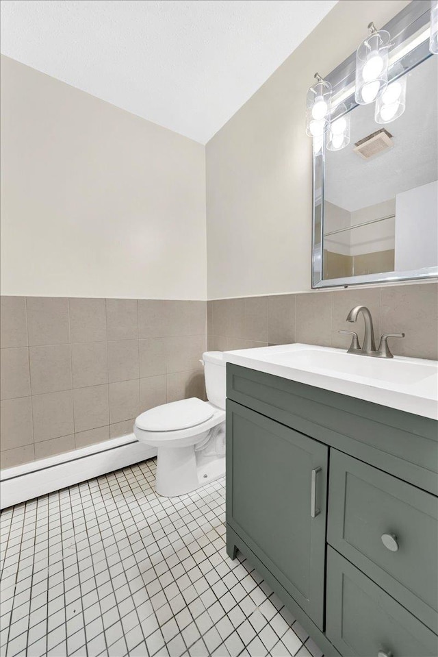 bathroom featuring toilet, tile walls, visible vents, tile patterned flooring, and a baseboard radiator
