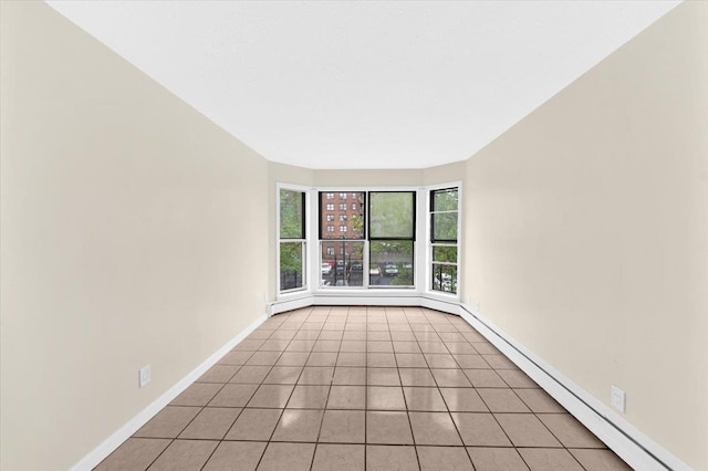 unfurnished room featuring light tile patterned flooring, baseboards, and baseboard heating