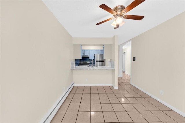 unfurnished living room featuring a sink, ceiling fan, a baseboard radiator, light tile patterned floors, and baseboards