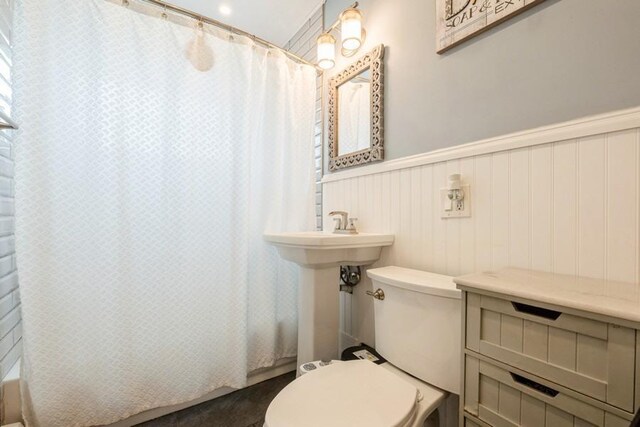 59 Springtime Ln S, Levittown, NY 11756 - bathroom with toilet, shower / tub combo, and a wainscoted wall