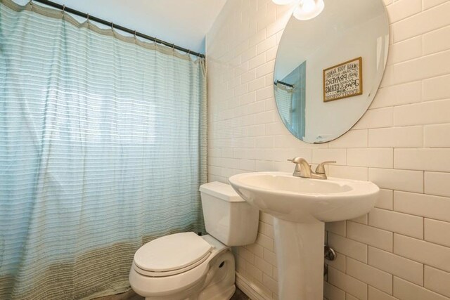 59 Springtime Ln S, Levittown, NY 11756 - bathroom with tile walls, toilet, a shower with curtain, and tasteful backsplash
