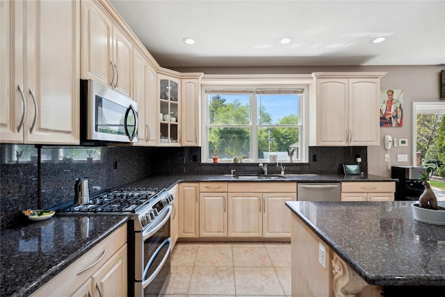 4 Millennium Ct, Bohemia, NY 11716 - kitchen with appliances with stainless steel finishes, light brown cabinets, light tile patterned flooring, decorative backsplash, and dark stone counters