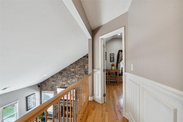 4 Millennium Ct, Bohemia, NY 11716 - corridor featuring wainscoting, lofted ceiling, light wood-style floors, an upstairs landing, and a decorative wall