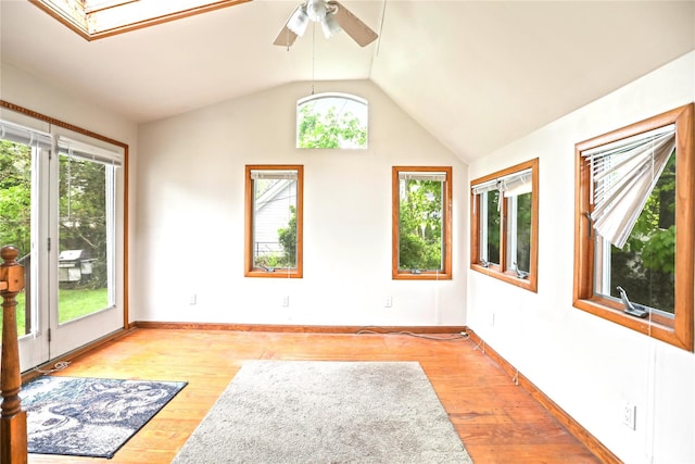 unfurnished room with lofted ceiling, baseboards, a ceiling fan, and light wood-style floors