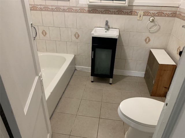 333 Lehrer Ave, Elmont, NY 11003 - bathroom with tile walls, tile patterned floors, toilet, vanity, and a tub to relax in