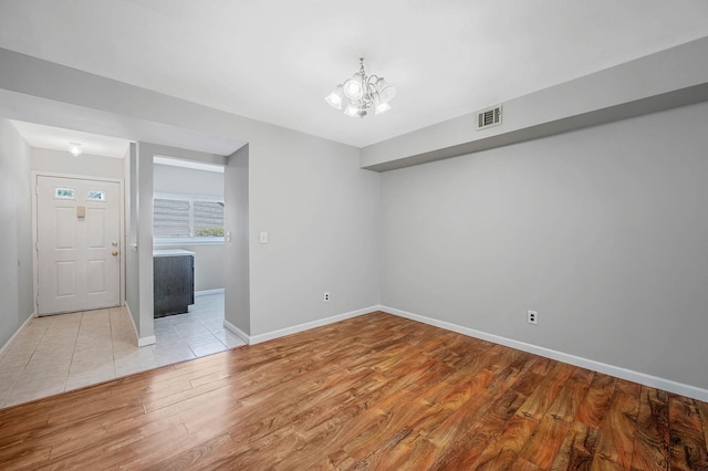 163 Pointe Cir N Unit 163, Coram, NY 11727 - spare room featuring light wood-type flooring, a chandelier, and baseboards