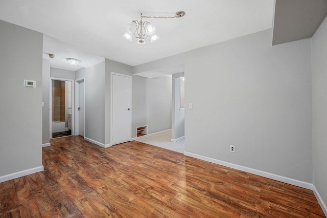 163 Pointe Cir N Unit 163, Coram, NY 11727 - unfurnished room with baseboards, wood finished floors, and a chandelier