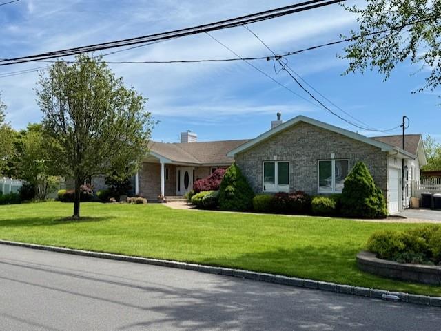 26 Haide Pl, East Islip, NY 11730 - ranch-style house with stone siding, an attached garage, and a front lawn