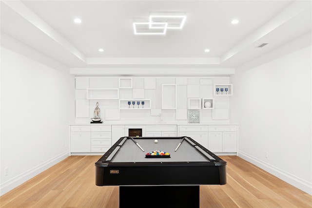 171 Oneck Ln, Westhampton Beach, NY 11978 - game room with baseboards, light wood-style floors, a tray ceiling, and bar