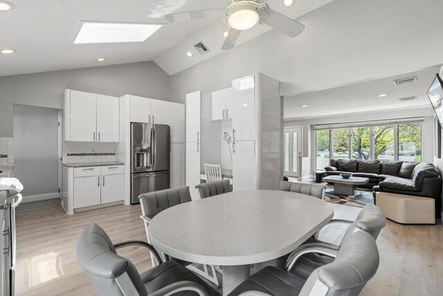 214 Central Park Rd, Plainview, NY 11803 - dining room featuring high vaulted ceiling, a skylight, light wood finished floors, recessed lighting, and ceiling fan