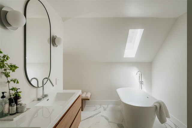 825 County Route 6, High Falls, NY 12440 - bathroom featuring a skylight, marble finish floors, vanity, a freestanding bath, and baseboards